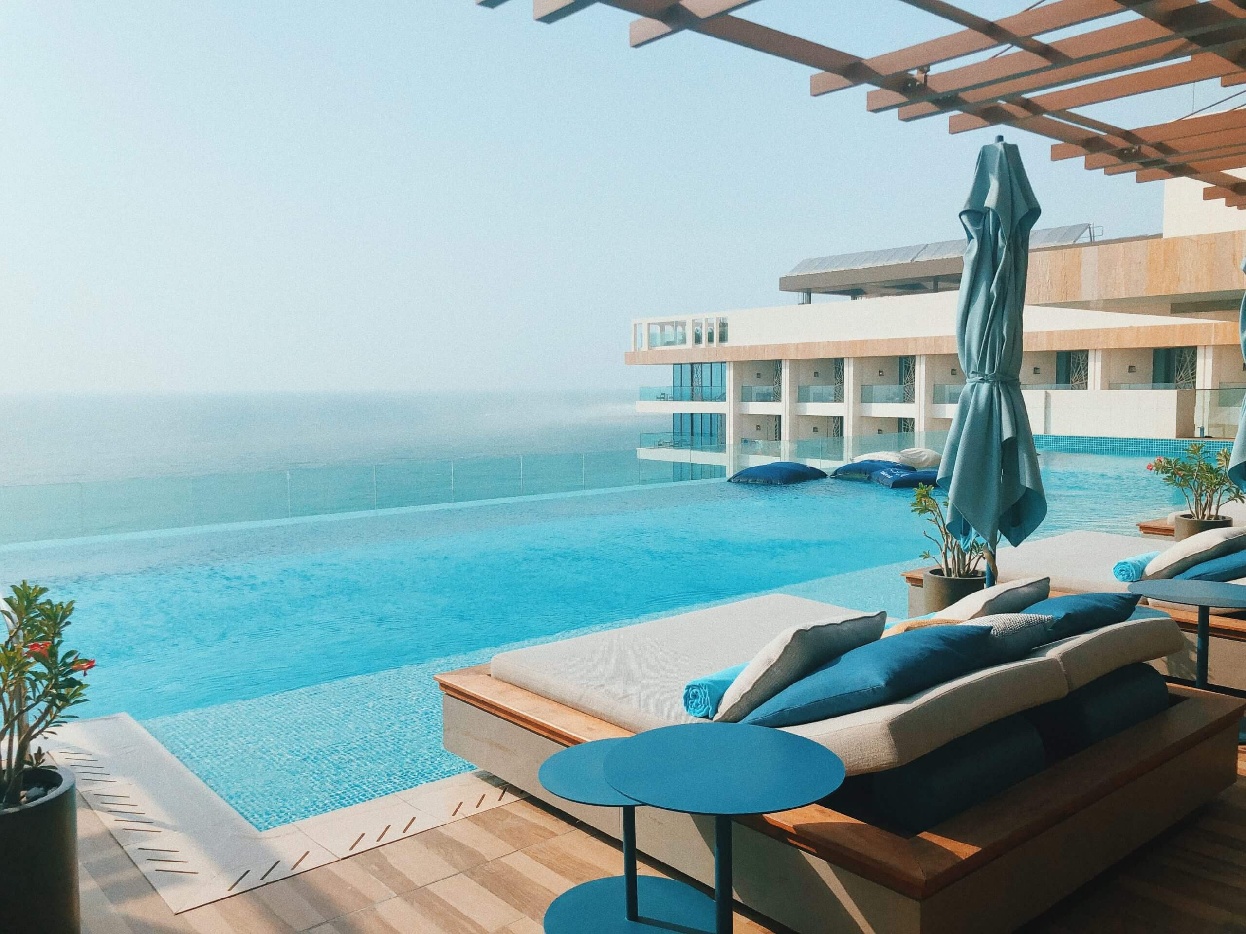 View looking over a luxury hotel swimming pool with a sea view.