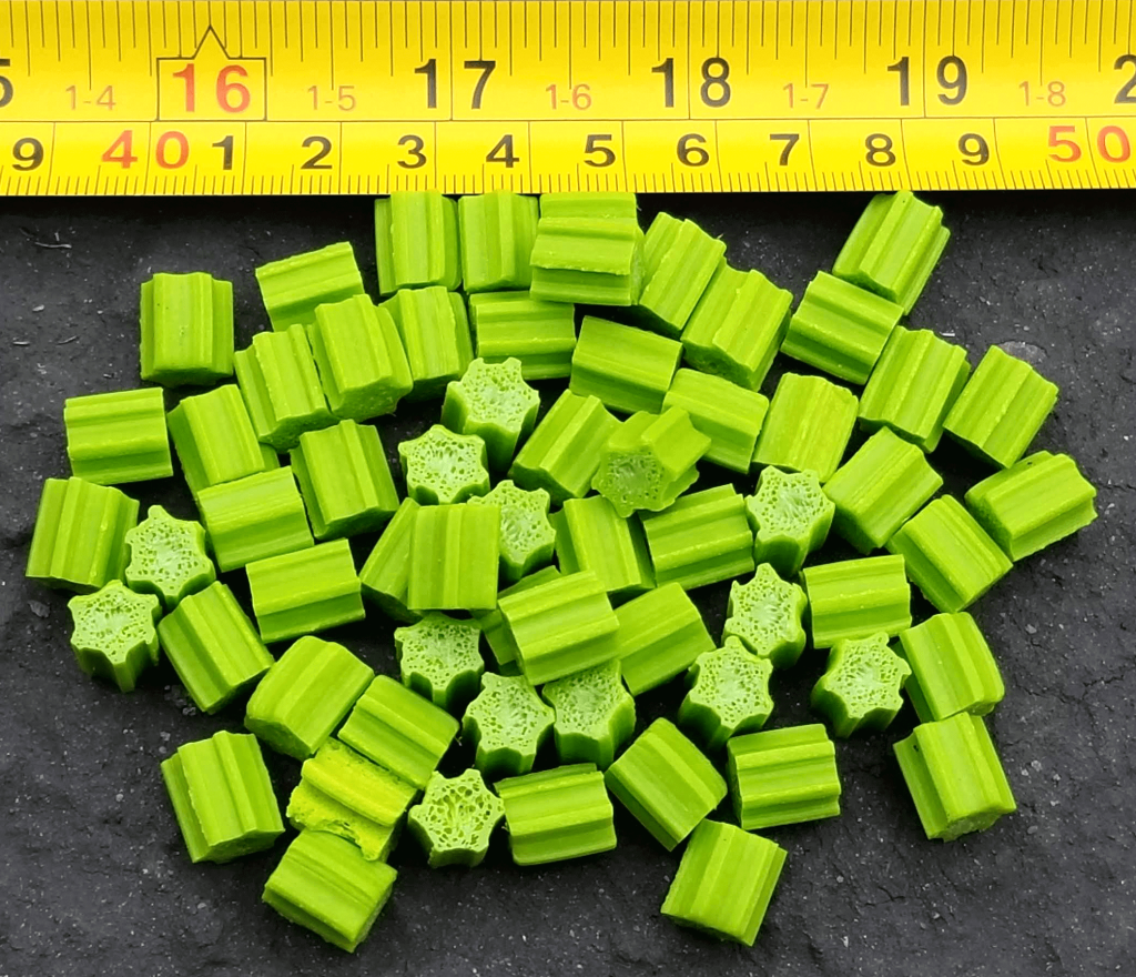  Close-up of green Powerchips Green digestion media beside a tape measure showing chip size.